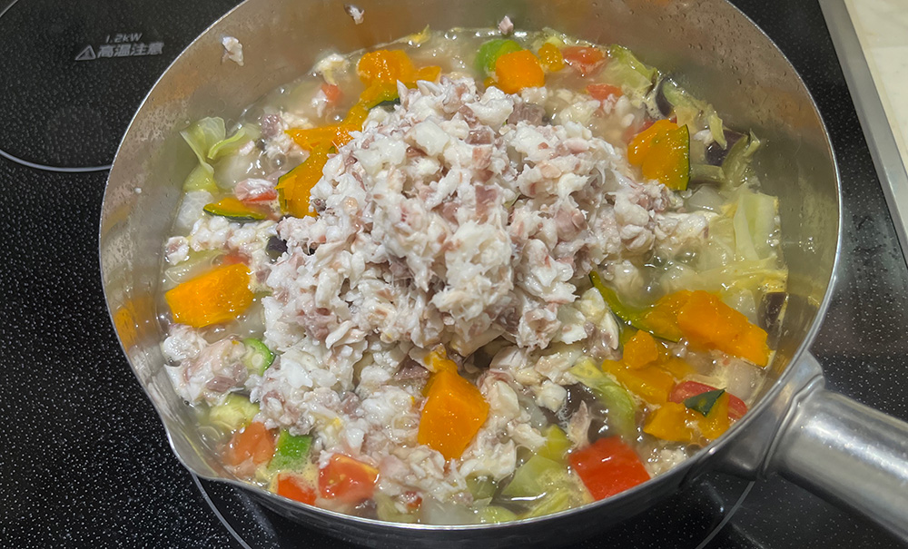 ほぐした鯛の身を野菜の鍋に戻す